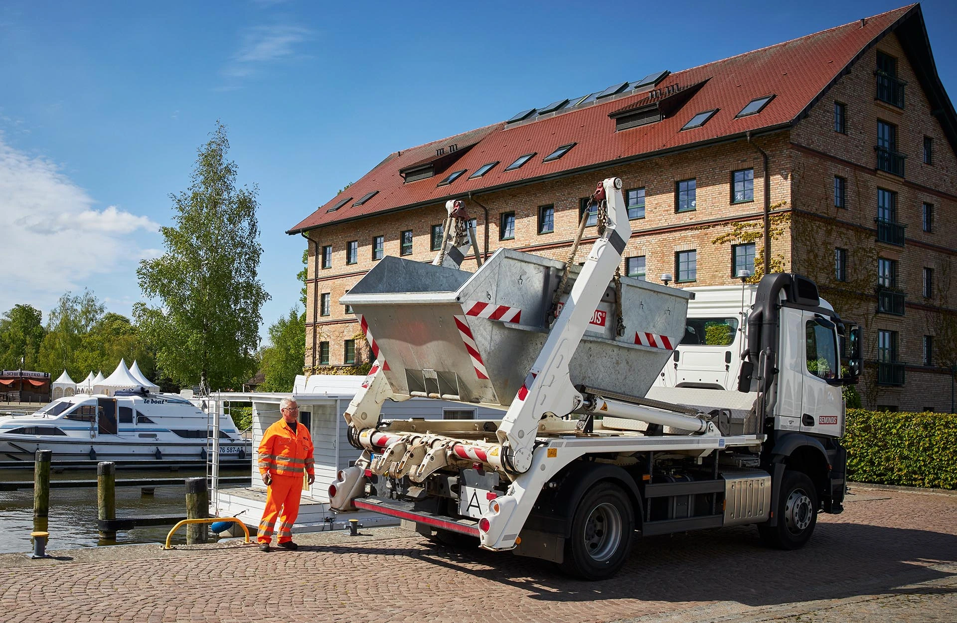 Mitarbeiter liefert einen Container mit dem Absetzkipper.