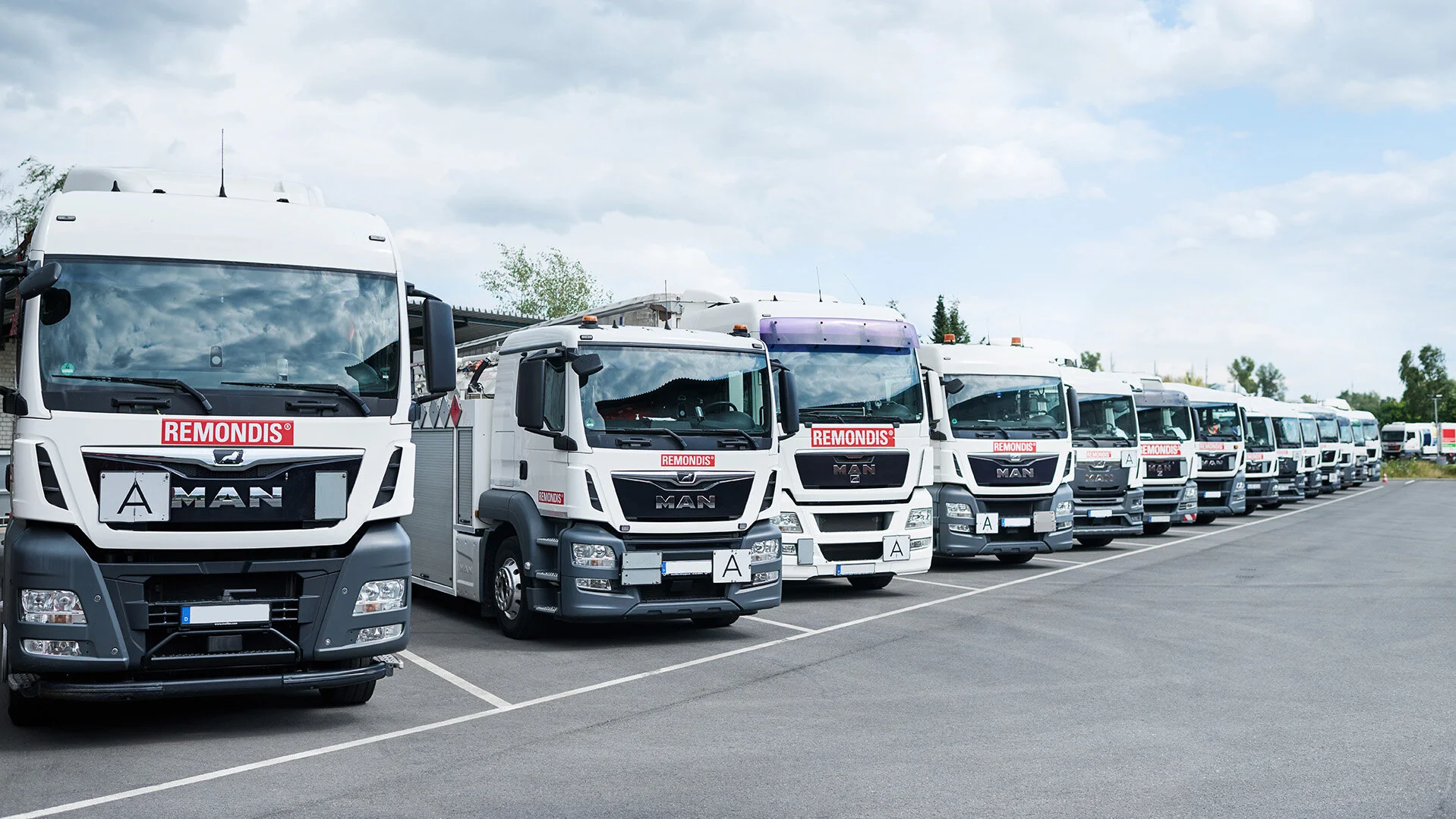 LKW-Fuhrpark zur Abfallsammlung auf einem Betriebsgelände.